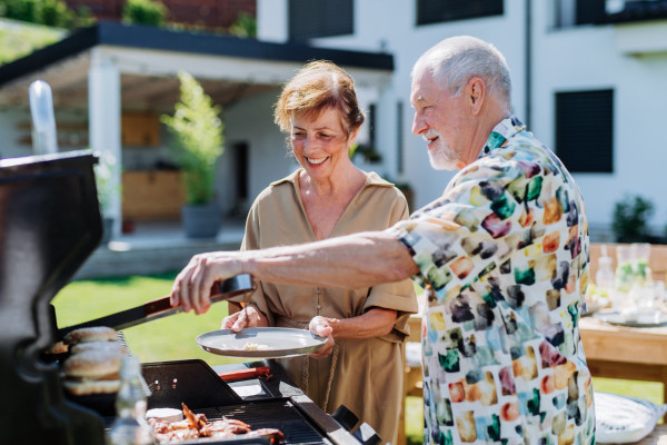 Starsza para grillująca jedzenie na grillu