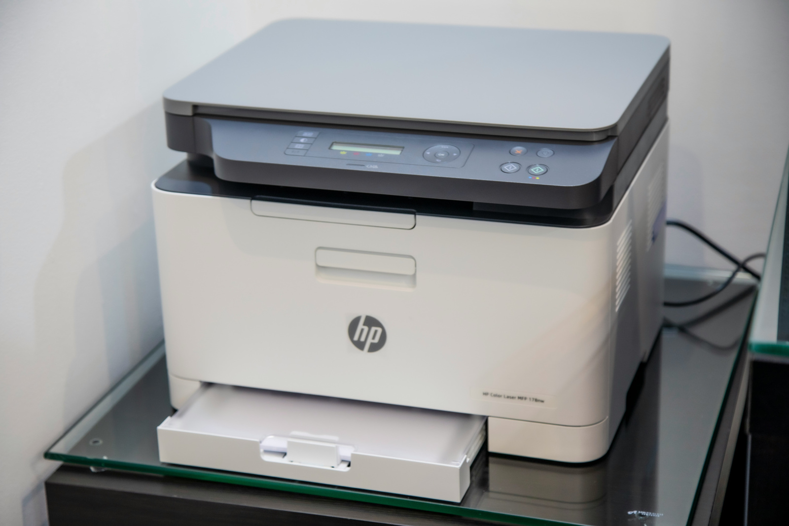 Drukarka laserowa HP na szklanej powierzchni.